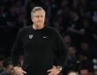 Minnesota Timberwolves head coach Chris Finch stands on the sideline with his hands on his hips during a playoff game.