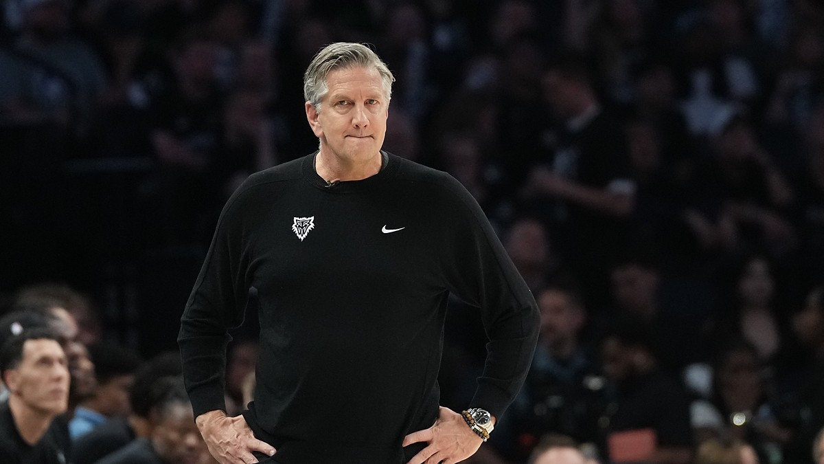 Minnesota Timberwolves head coach Chris Finch stands on the sideline with his hands on his hips during a playoff game.