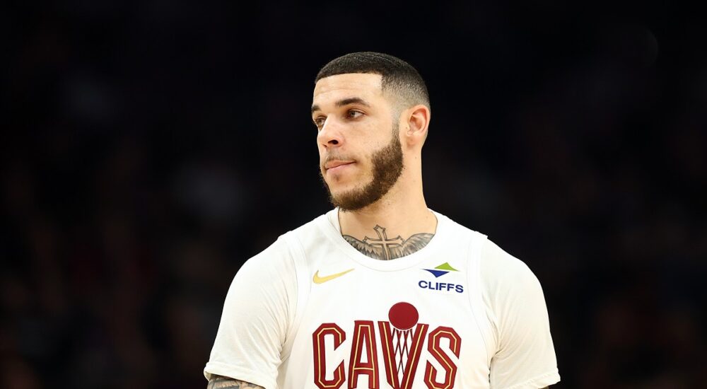 Cleveland Cavaliers guard Lonzo Ball looks toward the court in a white Cavs jersey.