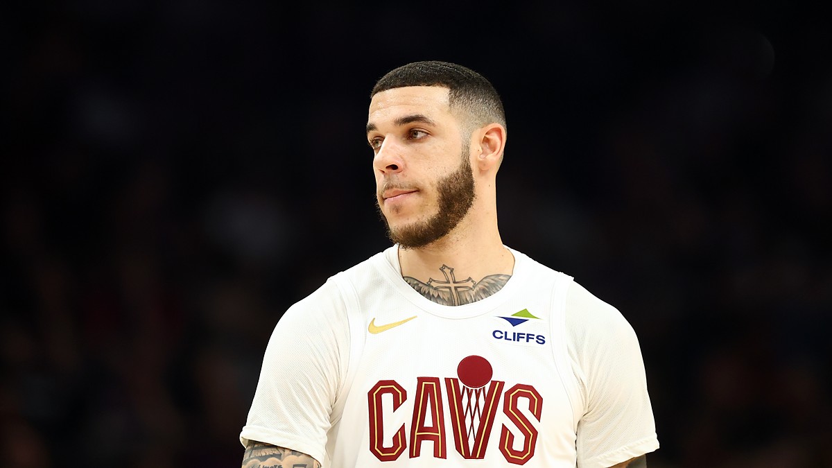 Cleveland Cavaliers guard Lonzo Ball looks toward the court in a white Cavs jersey.