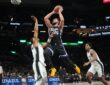 Sacramento Kings guard Ben Simmons rises for a shot between two San Antonio Spurs defenders near the basket.